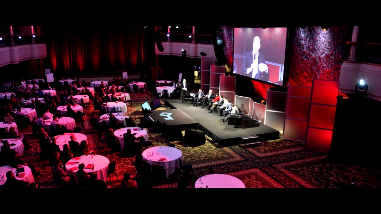 Large corporate event with a stage and seated audience