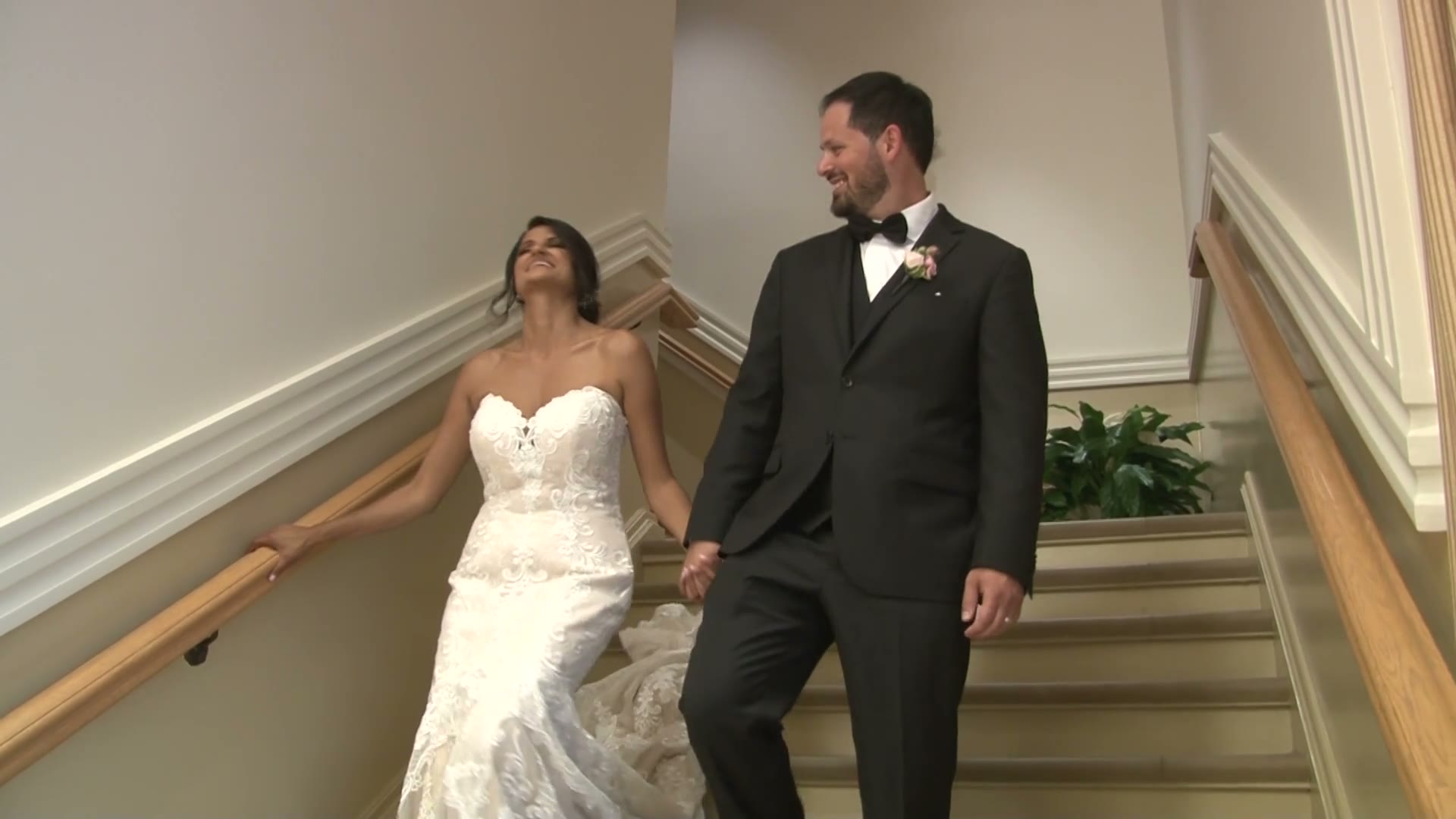 Bride and groom walking down a staircase on their wedding day